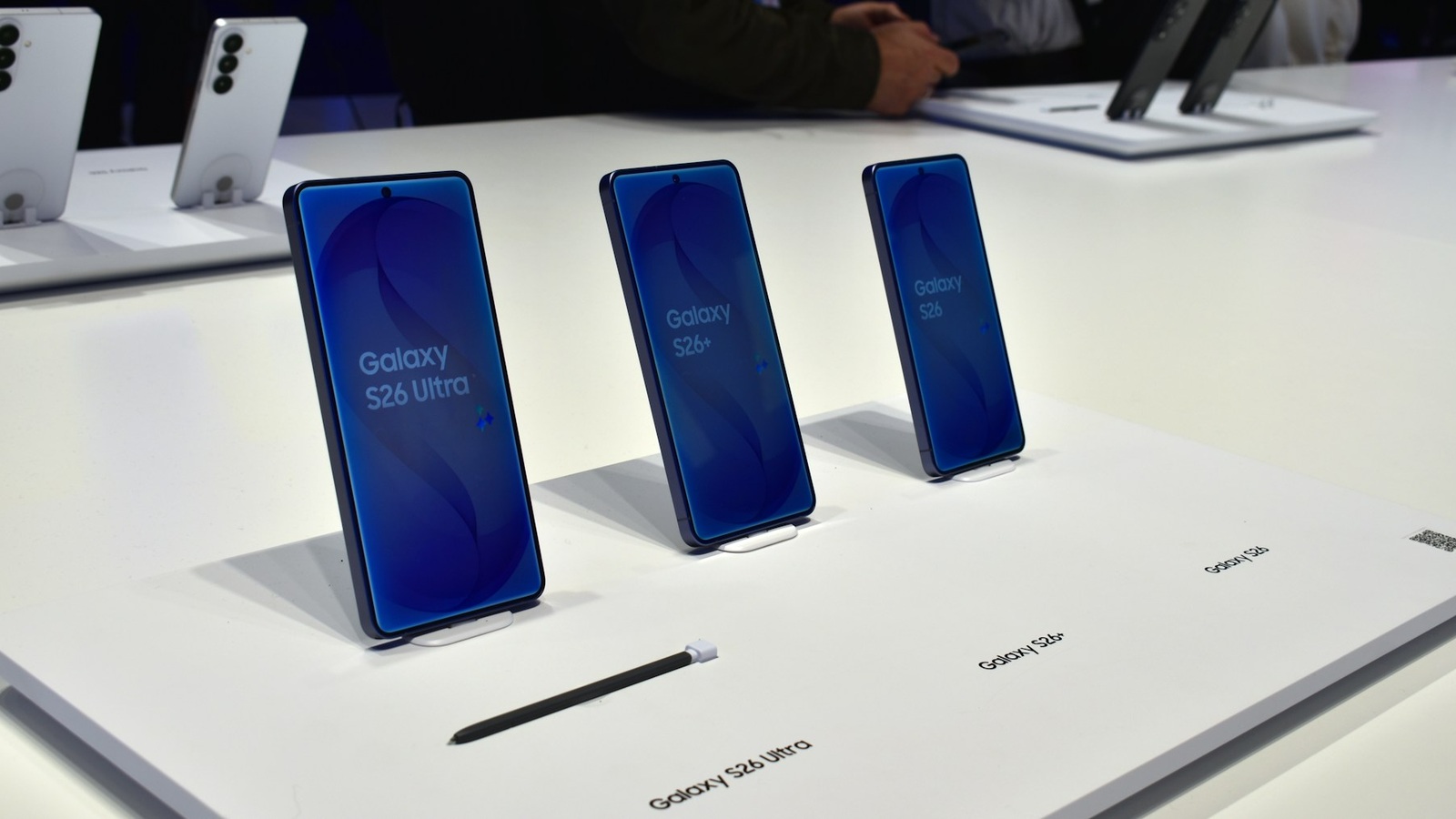 매장 진열대에 놓인 여러 색상의 최신 스마트폰들이 나란히 전시된 모습
